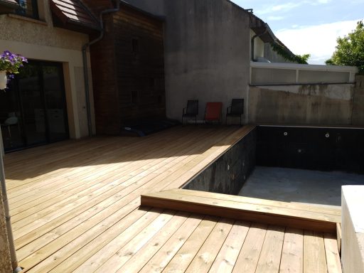 Aménagement d'une terrasse en bois pour habiller le contour d'une piscine et l'espace transat